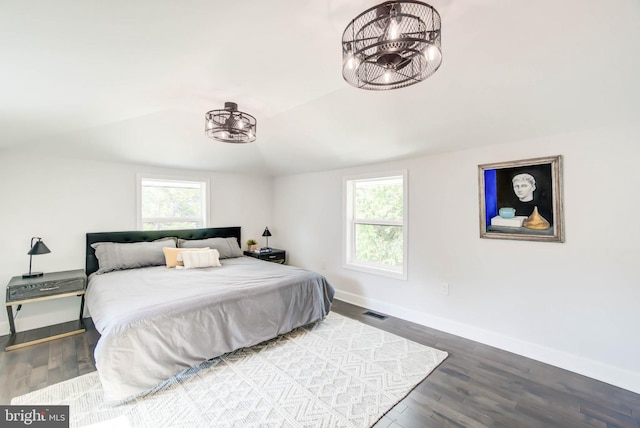 bedroom with lofted ceiling, wood-type flooring, and multiple windows