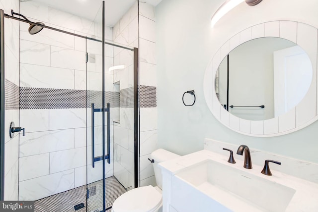 bathroom with vanity, a shower with shower door, and toilet