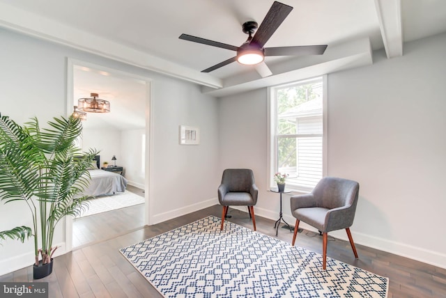 sitting room with ceiling fan, beamed ceiling, and dark hardwood / wood-style flooring