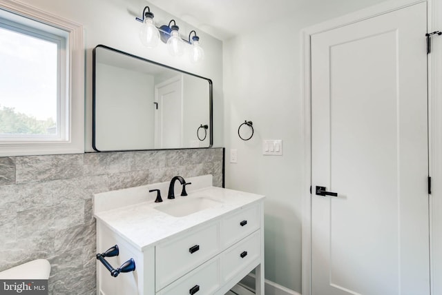 bathroom featuring vanity and tile walls