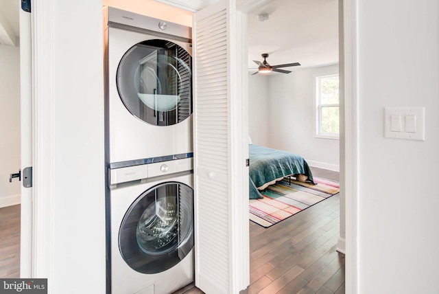 laundry area featuring stacked washer / dryer, wood finished floors, ceiling fan, and laundry area