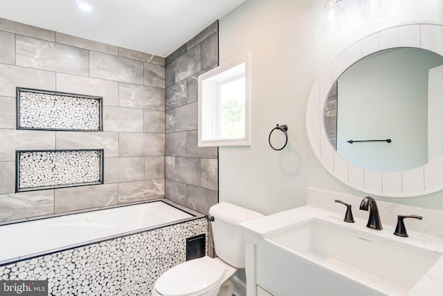bathroom featuring tiled shower / bath combo, toilet, and vanity