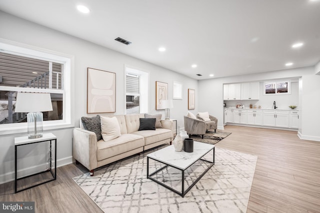 living area with visible vents, recessed lighting, light wood-style flooring, and baseboards