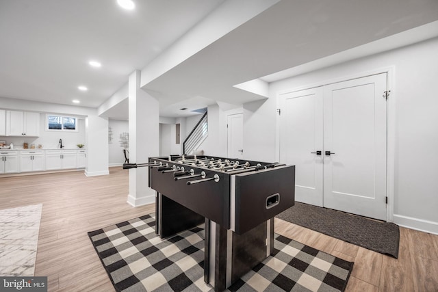 recreation room with recessed lighting, baseboards, bar area, and light wood-style floors