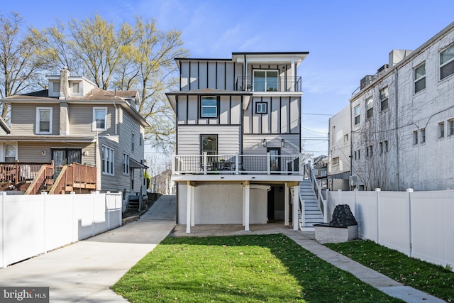 back of house featuring a wooden deck, a yard, and a garage