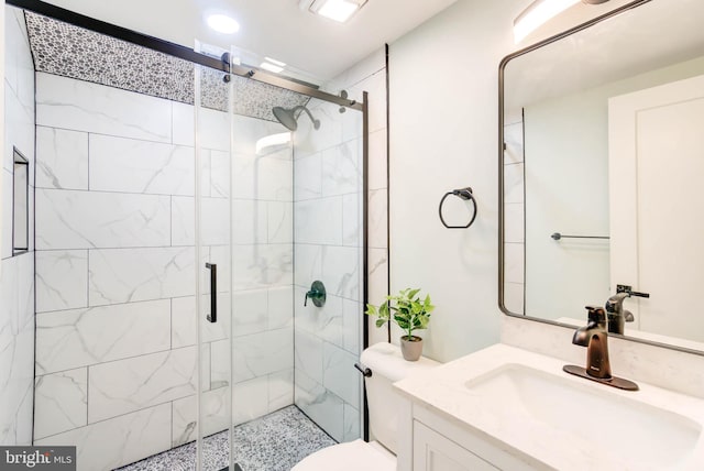 bathroom with toilet, a shower with shower door, and vanity