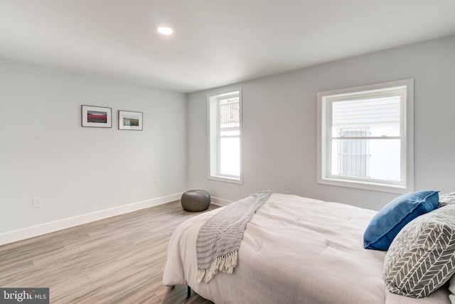 bedroom featuring wood finished floors, recessed lighting, and baseboards