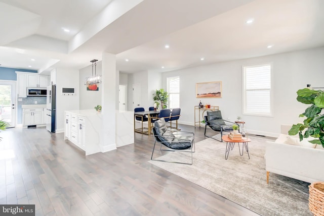 living area with wood finished floors, plenty of natural light, and recessed lighting