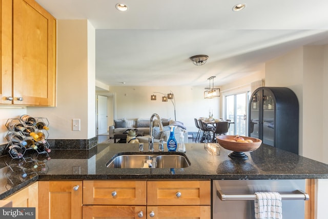 kitchen with sink, pendant lighting, and dark stone countertops