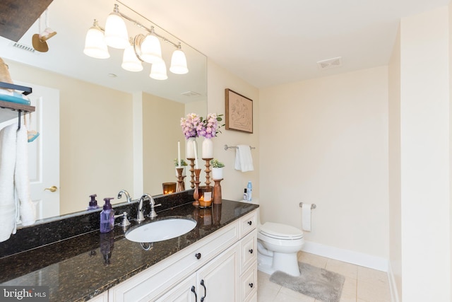 bathroom with toilet, vanity, and tile patterned floors