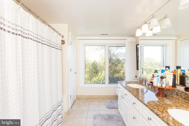 bathroom with vanity, toilet, a healthy amount of sunlight, and tile patterned floors