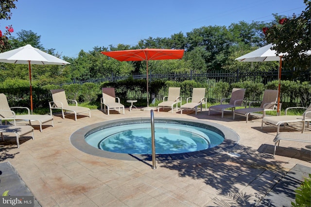 view of swimming pool with a patio and a hot tub