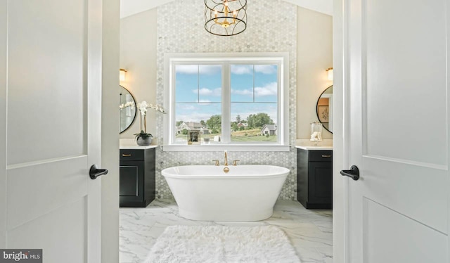 bathroom with vanity, a bathtub, tile walls, and an inviting chandelier