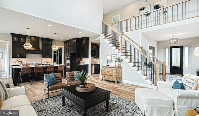 living room with a high ceiling and light wood-type flooring