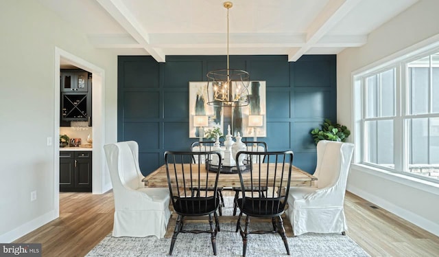 dining space with coffered ceiling, beam ceiling, a notable chandelier, and light hardwood / wood-style floors