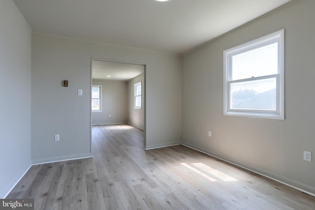 spare room with crown molding and light hardwood / wood-style flooring