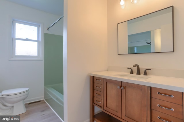 full bathroom with vanity, toilet,  shower combination, and hardwood / wood-style floors