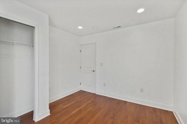 unfurnished bedroom with hardwood / wood-style flooring and a closet