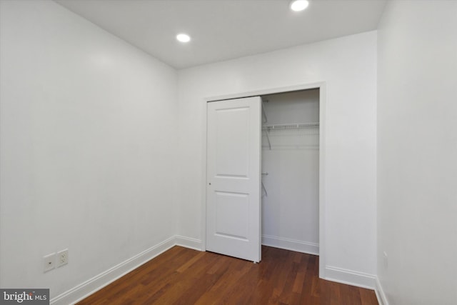 unfurnished bedroom featuring a closet and dark hardwood / wood-style floors