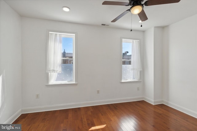 spare room featuring dark wood-type flooring and ceiling fan