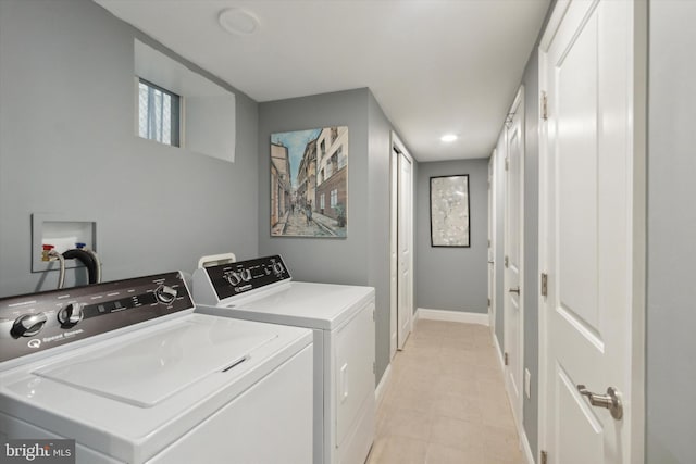 laundry room with washing machine and dryer and light tile patterned floors