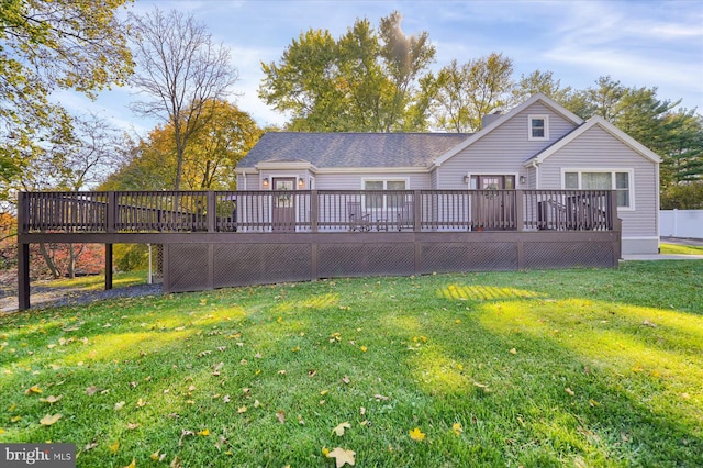 rear view of house featuring a deck and a lawn