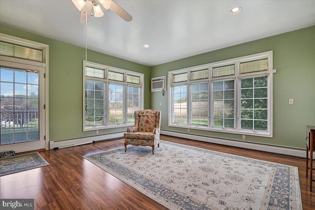 sitting room featuring a healthy amount of sunlight, a baseboard radiator, and dark hardwood / wood-style flooring