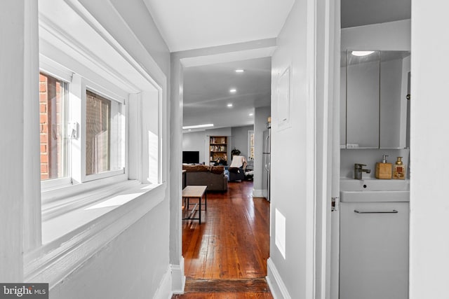 hall featuring sink, dark wood-type flooring, and vaulted ceiling