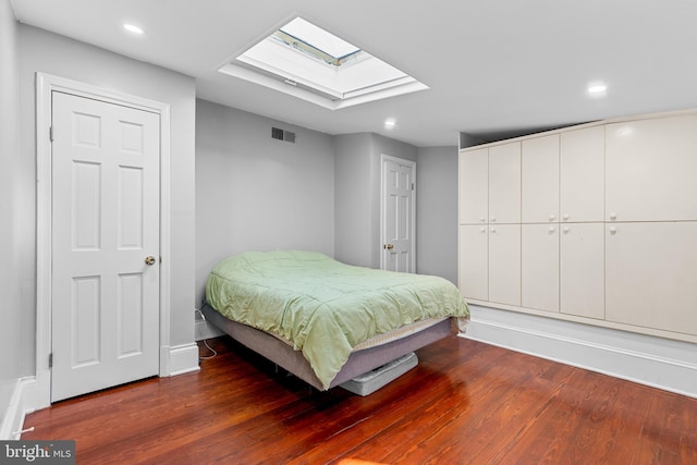 bedroom featuring hardwood / wood-style flooring and a skylight