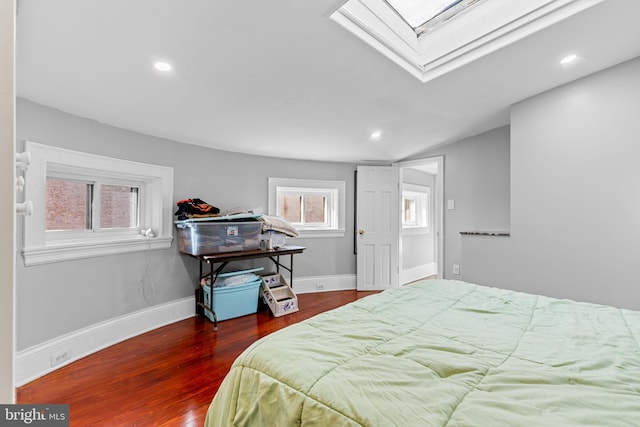 bedroom featuring dark wood-type flooring and vaulted ceiling with skylight