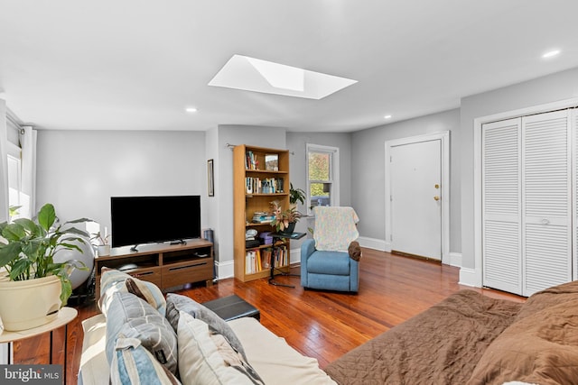 living room featuring lofted ceiling with skylight and wood-type flooring