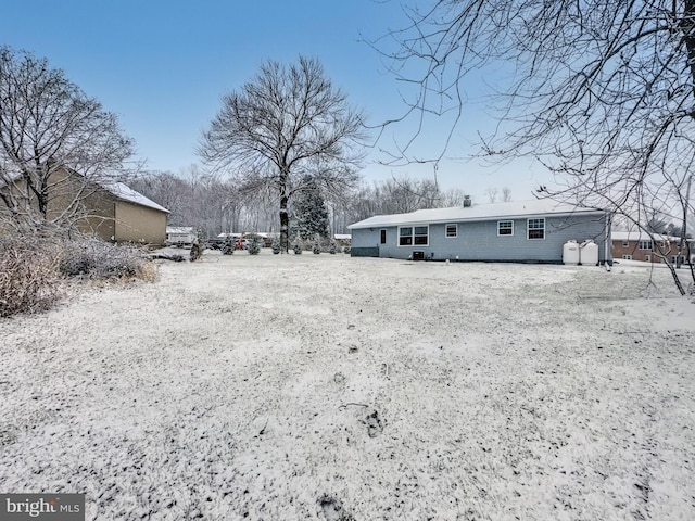 view of snow covered rear of property