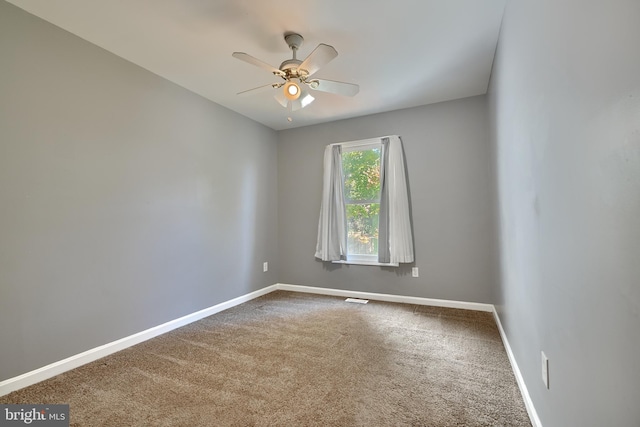 carpeted spare room with ceiling fan