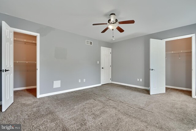 unfurnished bedroom with a spacious closet, ceiling fan, and carpet flooring