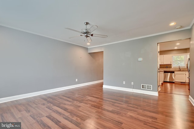 empty room with ceiling fan, crown molding, sink, and hardwood / wood-style floors