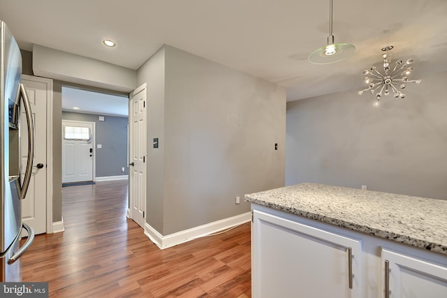 kitchen featuring a notable chandelier, stainless steel fridge with ice dispenser, hanging light fixtures, and wood-type flooring