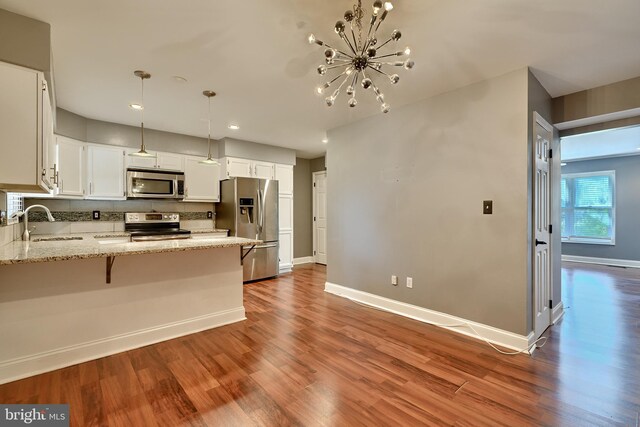 kitchen with hardwood / wood-style flooring, stainless steel appliances, sink, and white cabinets