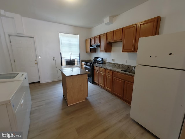 kitchen with a kitchen island, separate washer and dryer, light hardwood / wood-style floors, white fridge, and black gas range oven