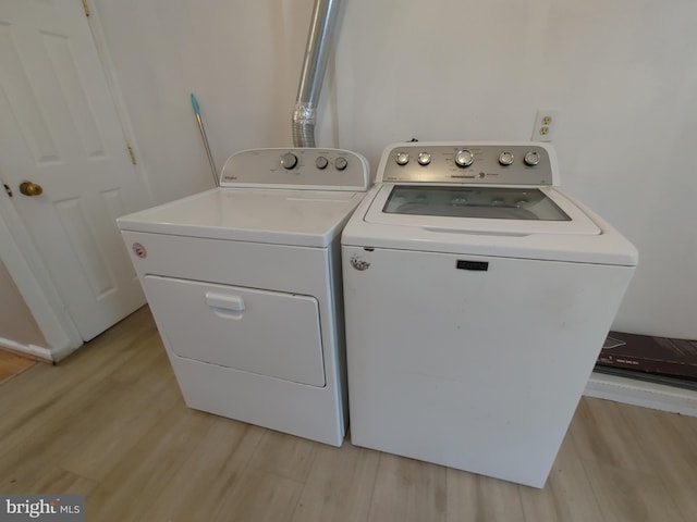 washroom with washing machine and clothes dryer and light wood-type flooring