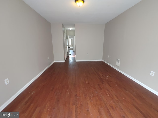 unfurnished room with dark wood-type flooring