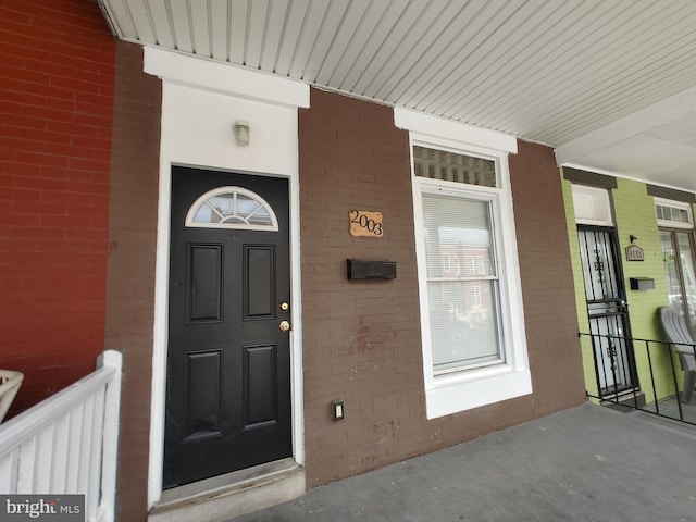 view of exterior entry featuring covered porch