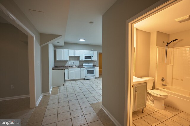 interior space with toilet, tile patterned flooring, vanity, and tub / shower combination