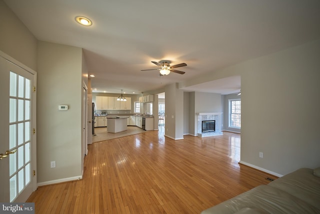 unfurnished living room featuring ceiling fan and light hardwood / wood-style floors