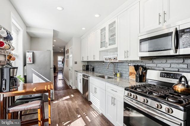 kitchen featuring white cabinetry, sink, stainless steel appliances, and light stone countertops