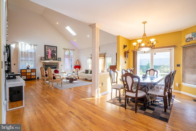 10 Eddie Ct, Dayton, NJ 08810 - dining space with high vaulted ceiling, a chandelier, light wood-style floors, a fireplace, and baseboards
