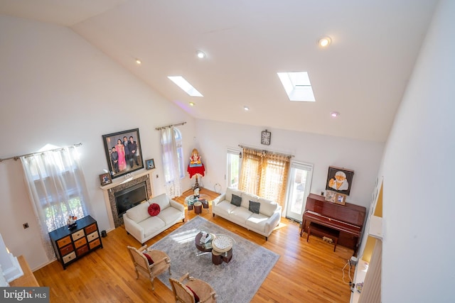 10 Eddie Ct, Dayton, NJ 08810 - living area featuring high vaulted ceiling, a tiled fireplace, light wood-style floors, and a skylight