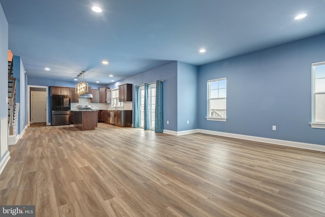 unfurnished living room featuring light wood-type flooring and sink