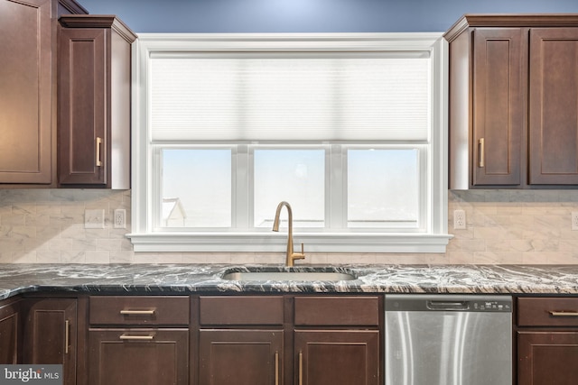 kitchen with dark brown cabinetry, sink, tasteful backsplash, stainless steel dishwasher, and dark stone countertops