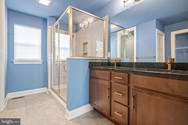 bathroom with tile patterned flooring, vanity, and a shower with shower door