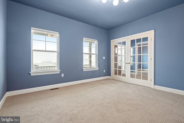 empty room with french doors and light colored carpet